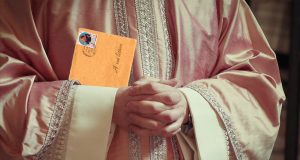 Un sacerdote con paramento liturgico rosa porta con se una lettera per voi lettori