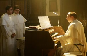 Un frate domenicano suona l'Organo, mentre due altri due frati cantano