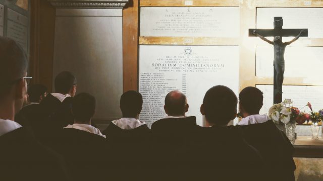 Frati che pregano per i domenicani al cimitero
