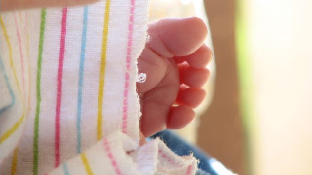 Piedino di un bimbo avvolto da una coperta