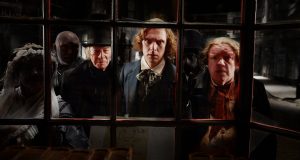 Tre uomini si affacciano verso l'interno di una finestra. Dal film "Dickens, l'uomo che inventò il Natale"