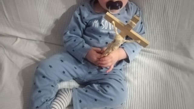 Bimbo tiene in mano crocefisso